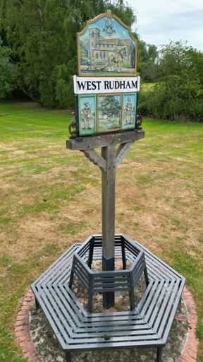 A vertical shot of the colorful West Rudham village sign in Norfolk, England