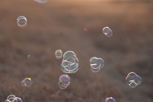 A closeup shot of soap bubbles in the air with a blurred background