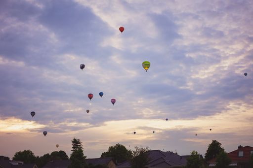 A low angle shot of floating hot air balloons for a festival in a sunset sky in Hardenberg,Netherlands