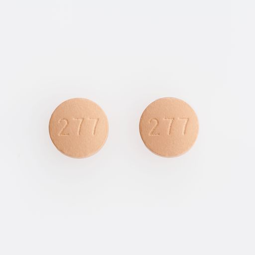 A closeup shot of two round medical pills isolated on a white background