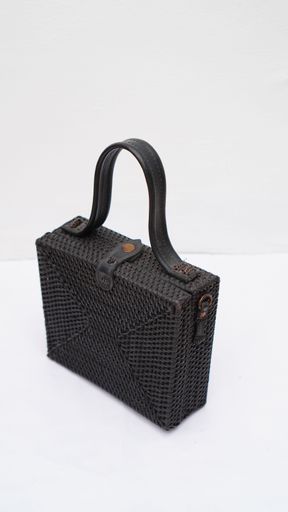 A vertical shot of a black handbag isolated on a white background