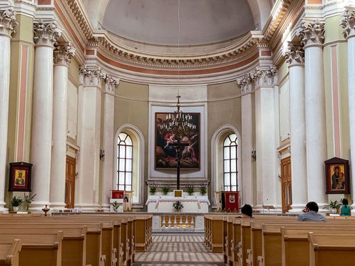 A beautiful shot of the interior of a church and people sitting on the benches