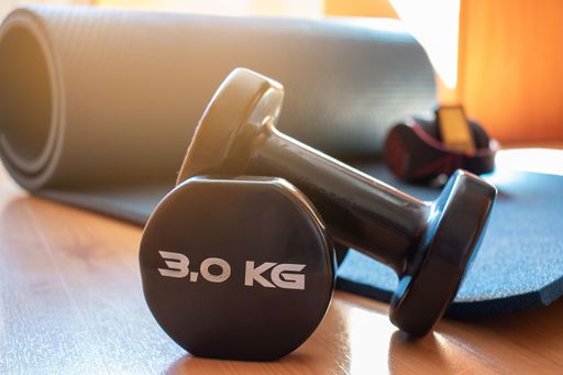 Pair of dumbbells for home training with yoga mat. Concept: fitness at home.
