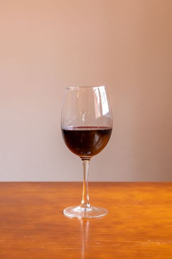 a closeup of a red wine glass on a table