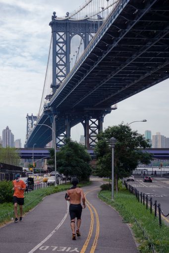 A vertical shot of the Manhattan bridge in New York City in cloudy sky background