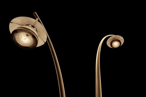 A low-angle shot of street lamps in the dark