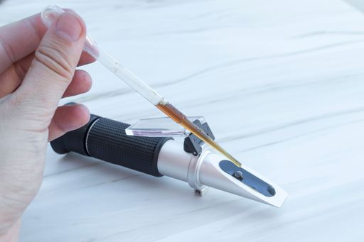 Man using a refractometer device for the measurement of an index of refraction