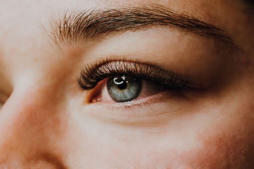 A closeup of a beautiful blue eye and long lashes of a woman