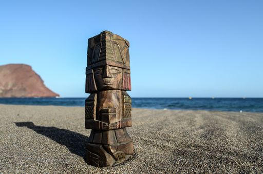 A closeup shot of an ancient Maya set on the beach with the calm blue ocean in the background
