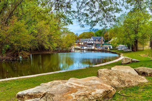 A scenic view of a river where one side is filled with trees and the other with buildings