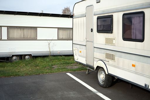 A vertical shot of white Camper vans parked in a parking lot