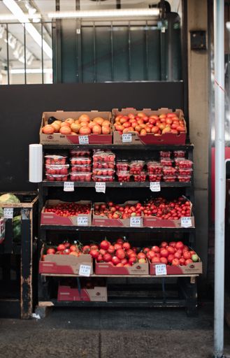A vertical shot of a fruit stand full of tomatoes.