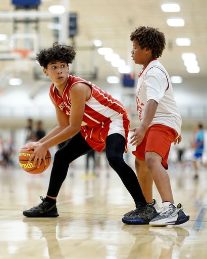 A group of young players actively playing basketball