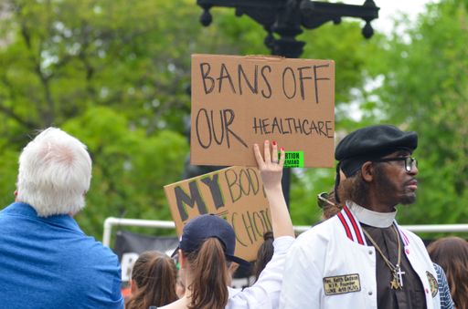 A closeup of people rallying against the abortion ban in New York against a blurred background