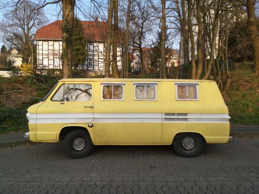 A closeup of an old yellow classic vehicle parked outdoors on the streets