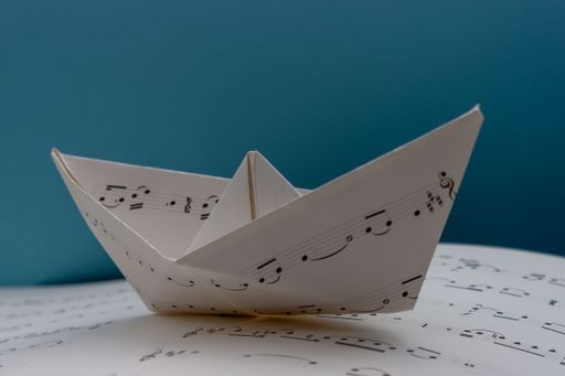 A closeup shot of a beautiful origami of a boat from the music notes paper