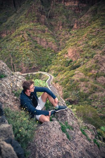 A Caucasian male hiker on top of a mountain during sunset in Masca, Tenerife, Spain