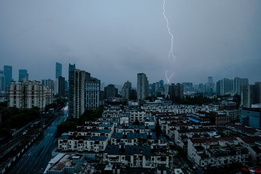 A city skyline with lightning during thunderstorm and cloudy sky