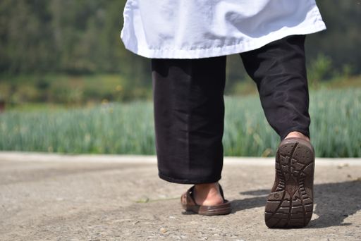 A shallow focus shot of a person's legs from behind during walking