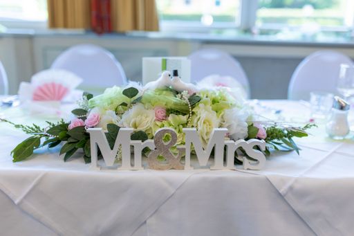 A close-up shot of a table decoration with flowers and Mr & Mrs sign