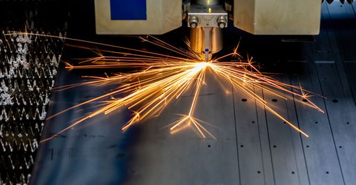 An automated stainless steel cutting machine produces sparks while in motion