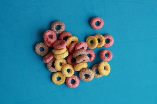A high angle shot of colorful fruit loops isolated on a blue surface