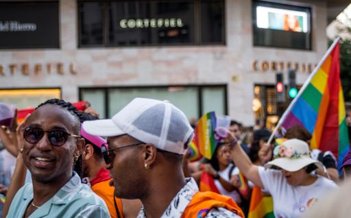 Picture of Couple of Black African American Homosexual Black Boys at the Gay Pride Parade with Rainbow Flag in the background