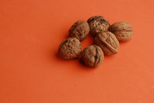 A high angle shot of six walnuts isolated on an orange surface