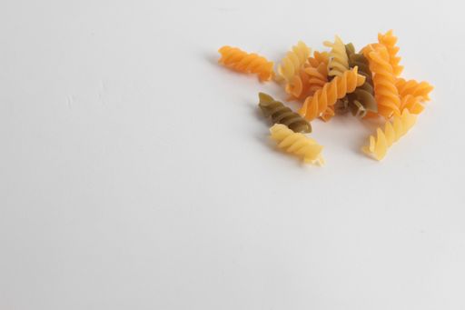 A closeup of raw fusilli pasta on white surface