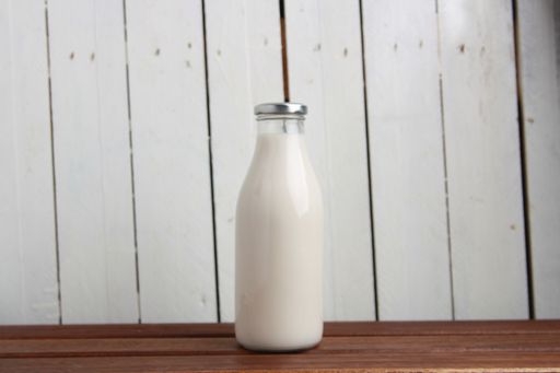 A closeup shot of a glass bottle with milk