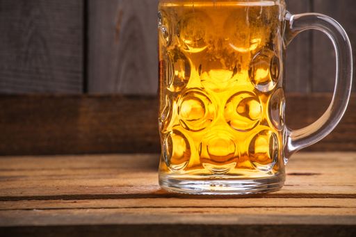A closeup shot of a big mug of beer on a wooden table