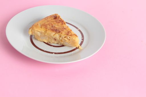 A high angle shot of a plate of homemade chicken pie isolated on a pink surface