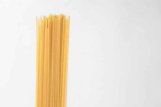 A high angle shot of a pile of uncooked spaghetti isolated on a white surface