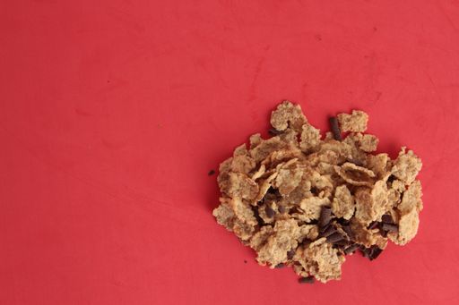 A high angle shot of a pile of cornflakes isolated on a pink surface