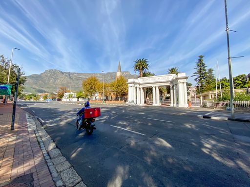 A delivery driver driving past the Mount Nelson Hotel with Table Mountain in the background during coronavirus lockdown level 4