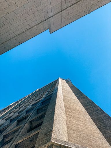 A vertical low angle shot of stone buildings under a clear sky
