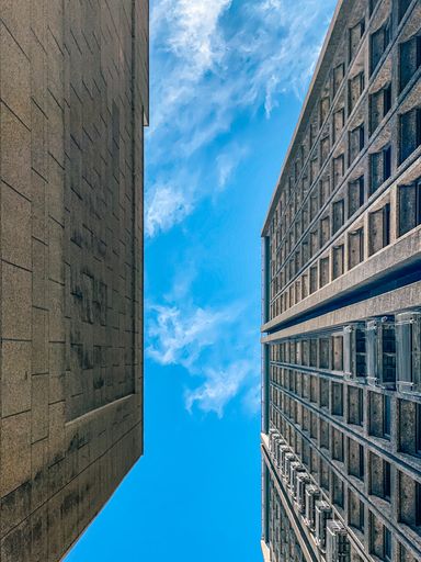 A vertical shot of tall modern buildings under a blue clear sky