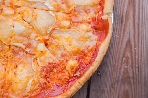 A high angle shot of a delicious homemade pizza on a wooden surface