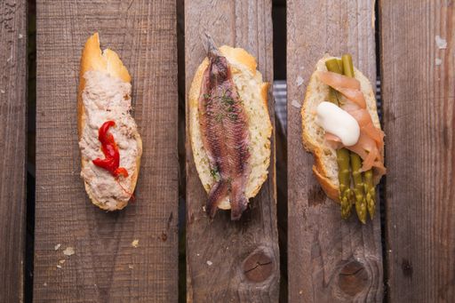 A high angle closeup shot of Spanish tapas on a wooden table