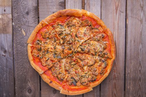A closeup shot of delicious homemade pizza on a wooden surface