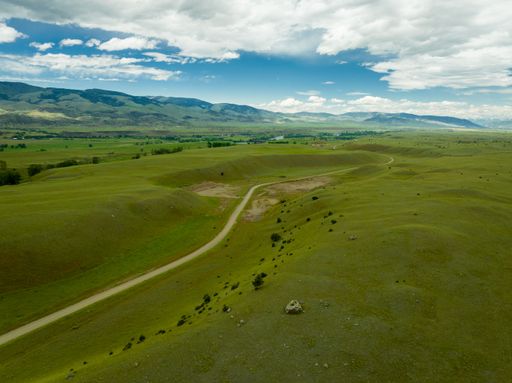 A gorgeous aerial view of tall mountains in the Paradise Valley in Montana under a bright cloudy sky