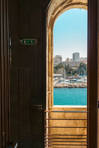 a vertical shot of a doorway looking out to blue water