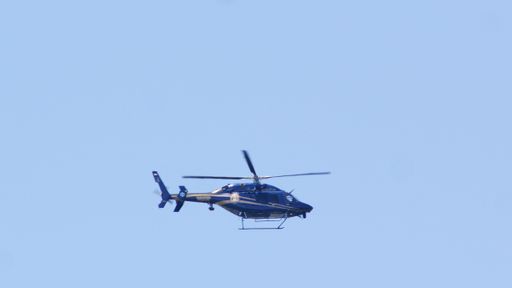 A Delaware State Trooper helicopter fly in the blue sky