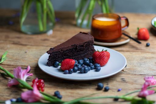 A closeup shot of a piece of brownie cake with blueberries and strawberries