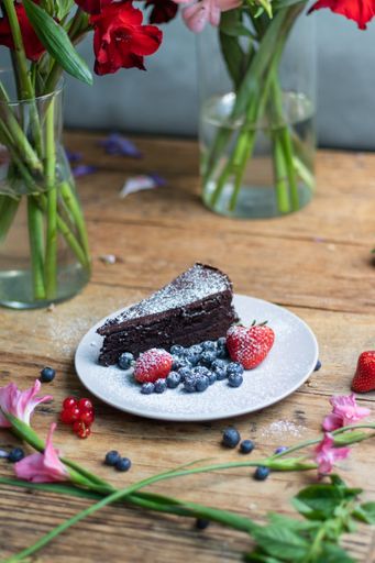 A closeup shot of a piece of brownie cake with blueberries and strawberries