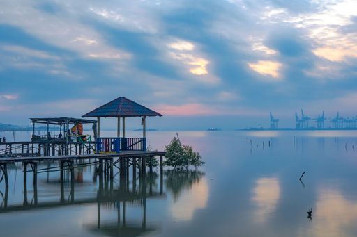 A scenic view of a wooden dock over a calm lake during sunset