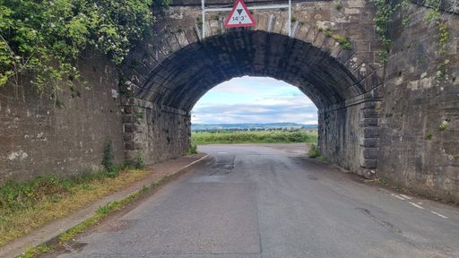 A beautiful view of a stone bridge over an empty road