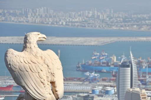A proud white stone eagle watching over Haifa's port and sea on a sunny day in Israel