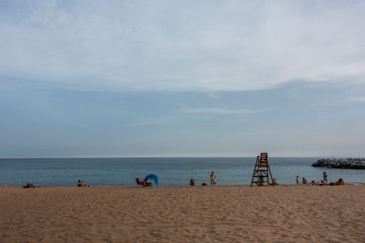A seascape with people resting at the beach