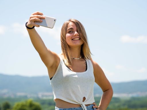 A young attractive female taking a selfie with her smartphone